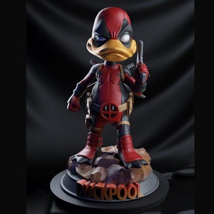 May include: A red and black action figure of a duck dressed as Deadpool. The figure is holding a gun in its right hand and has a red and black belt with a yellow buckle. The figure is standing on a rock base with the word "DUCKPOOL" written on it.