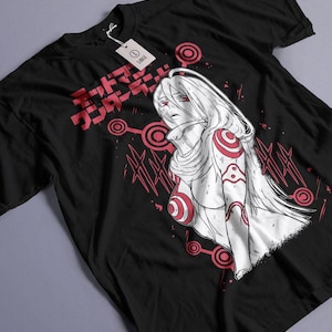Peut inclure: T-shirt noir avec une illustration de style anime d'un personnage féminin aux cheveux blancs et aux détails rouges. Le design comprend du texte japonais et des motifs circulaires. Une étiquette indique "LARGE".