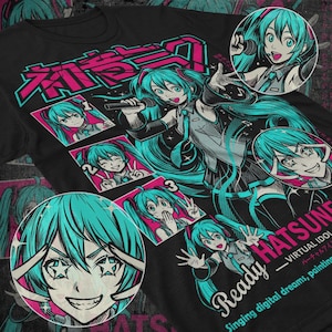 Op de afbeelding: Zwart t-shirt met een levendige illustratie van een anime-personage met turkoois haar. Het ontwerp bevat Japanse tekst en de woorden "Ready Hatsune", evenals de zin "Singing digital dreams, painting".