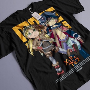 以下が含まれることがあります： メイドインアビスのアニメキャラクター2人が描かれた黒いTシャツ。キャラクターはリコとレグ。Tシャツには日本語で「メイドインアビス」と書かれている。
