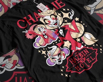 May include: Black t-shirt with a red and white graphic of characters from the animated series "Hazbin Hotel". The graphic features the text "Charlie" and "Hazbin Hotel" with a red star design.
