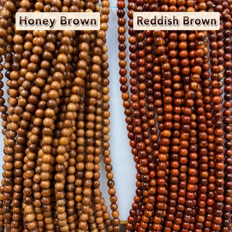May include: Two vertical strands of round wooden beads. The left strand is labeled Honey Brown and features light tan, smooth beads. The right strand is labeled Reddish Brown and consists of darker, deep mahogany-colored wooden beads.