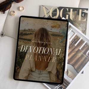 May include: A digital tablet displaying a devotional planner with the text "WITH MARRIED RICHES DEVOTIONAL PLANNER" on a white background. The tablet is surrounded by magazines.