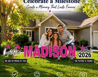 May include: A yard sign display featuring the name MADISON in large pink letters, the year 2026, and the text Congratulations, We are so proud of you, and The future is yours. A family of three sits on the grass in front of a house.