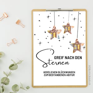 Könnte beinhalten: Eine weiße Karte mit schwarzem Text und Illustrationen von Sternen mit Geld darin. Der Text lautet "Greif nach den Sternen" und "Herzlichen Glückwunsch zum bestandenen Abitur".