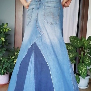 Puede incluir: Una falda larga de mezclilla con un dise&ntilde;o de patchwork. La falda est&aacute; hecha de diferentes tonos de mezclilla azul y tiene un dobladillo deshilachado.