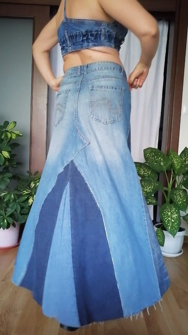 Puede incluir: Una falda larga de mezclilla con un dise&ntilde;o de patchwork. La falda est&aacute; hecha de diferentes tonos de mezclilla azul y tiene un dobladillo deshilachado.