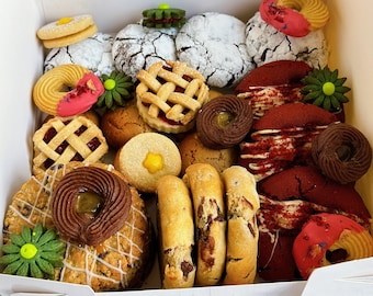 May include: A selection of cookies in a white box. The cookies include chocolate chip, red velvet, sugar, and shortbread. There are also some decorated cookies with flowers and sprinkles.