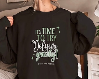 ウィキッド ミュージカル クルーネック スウェットシャツ | ミュージカル シアター スウェットシャツ | ブロードウェイ グッズ | デファイング グラビティ スウェットシャツ | ウィキッド スウェットシャツ