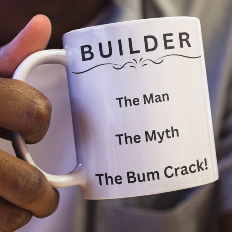 Puede incluir: Taza de cer&aacute;mica blanca con asa negra. La taza tiene la palabra "BUILDER" impresa en negro, seguida del texto "The Man", "The Myth" y "The Bum Crack!" en negro.