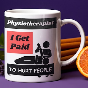 Puede incluir: Taza de cerámica blanca con un diseño en negro y rojo. La taza tiene el texto "Physiotherapist I Get Paid To Hurt People".