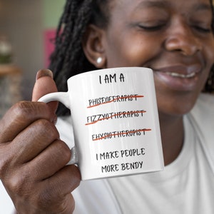A white 11oz ceramic coffee mug for Physiotherapists with the funny caption "I am a Physiotherapist" But it is crossed out three times miss spelt. The caption then says at the bottom "I make people more bendy"