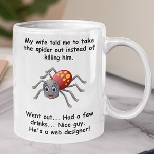May include: White ceramic mug with a black and red cartoon spider and the text "My wife told me to take the spider out instead of killing him. Went out... Had a few drinks... Nice guy. He's a web designer!"