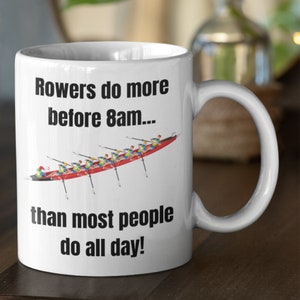 Puede incluir: Taza de café de cerámica blanca con un gráfico negro de un equipo de remo y el texto "Rowers do more before 8am... than most people do all day!"