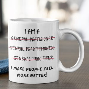 May include: White ceramic mug with the text "I AM A" above crossed-out misspellings of "General Practitioner" and the phrase "I MAKE PEOPLE FEEL MORE BETTER!" in black lettering.
