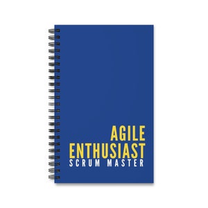 May include: A blue spiral notebook with the text "Agile Enthusiast Scrum Master" in yellow.