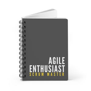 May include: A gray spiral notebook with the text "Agile Enthusiast Scrum Master" in white and yellow lettering.
