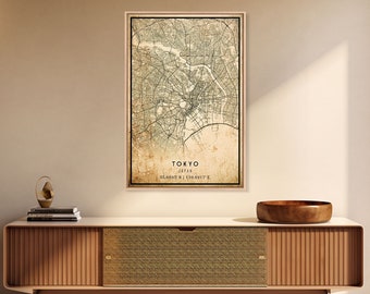 Könnte beinhalten: Eine gerahmte Karte von Tokio, Japan, mit Vintage-Ästhetik. Die Karte zeigt die Straßen und Wahrzeichen der Stadt in Grün- und Brauntönen. Der Text "TOKYO JAPAN" und Koordinaten sind sichtbar. Der Rahmen ist aus hellem Holz.