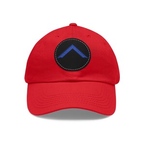 May include: Red baseball cap with a black and blue patch featuring a compass symbol.