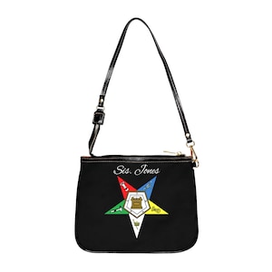 May include: Black shoulder bag with a star emblem featuring red, blue, green, and yellow points. The bag has a black strap and the text "Sis. Jones" is above the star design. The bag has a gold zipper and hardware.