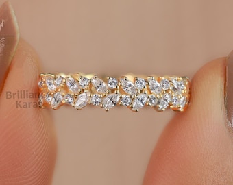 May include: A gold band ring with a double row of marquise-shaped clear stones.