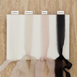 May include: Four samples of ribbon in different colors: Cotton (white), Almond (cream), Rose (pale pink), and Caviar (black).