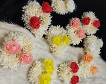 May include: Assortment of white flower hair ornaments with various colored fabric roses. The roses are in shades of red, pink, yellow, and orange.