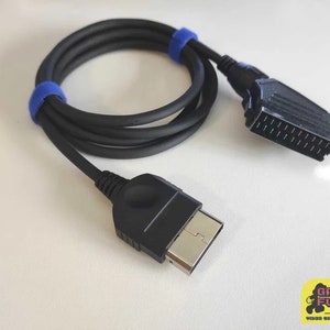 Könnte beinhalten: Schwarzes Kabel mit blauen Bändern, ein Ende hat einen SCART-Stecker und das andere Ende einen S-Video-Stecker.