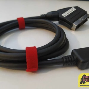 Può includere: Cavo nero PlayStation 2 a SCART con fascette per cavi rosse. Il cavo ha un connettore PlayStation 2 a un'estremità e un connettore SCART all'altra estremità.