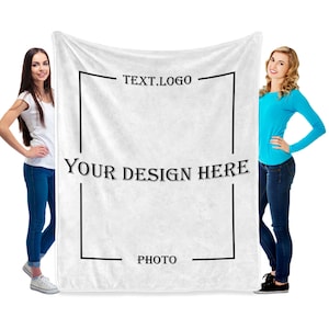 May include: Two people stand in front of a white fleece blanket with a black frame. The frame has the text "TEXT.LOGO" at the top, "YOUR DESIGN HERE" in the middle, and "PHOTO" at the bottom.