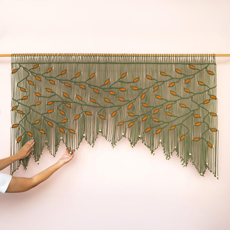 Intricate geometric macrame header transitioning into a sweeping leaf-patterned fringe.
