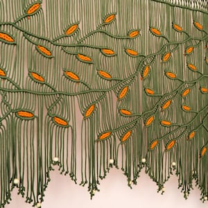 Unique housewarming gift: a handcrafted olive green and burnt orange macrame piece.