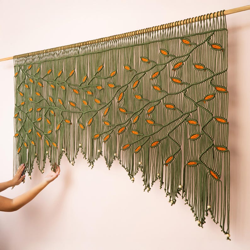 Nature-inspired fiber wall art with an olive green background and falling orange leaf design.