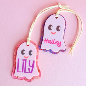 two personalized name tags, each with a unique name and a cute, ghost-like design.