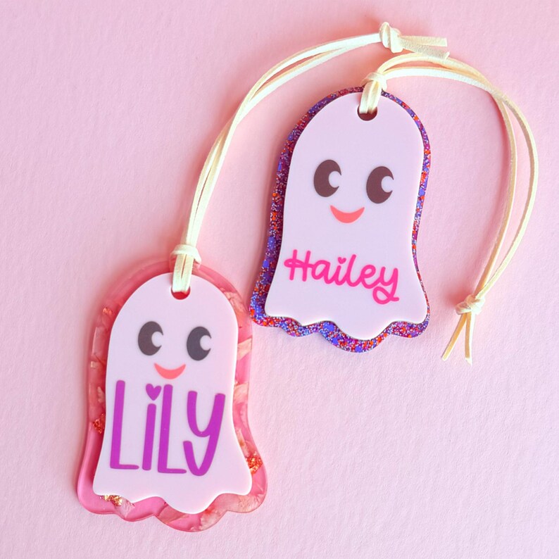 two personalized name tags, each with a unique name and a cute, ghost-like design.