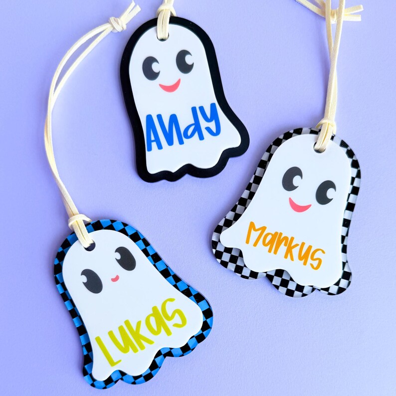 three personalized name tags with a ghost theme, each with a different name and color.
