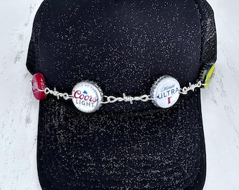 Barbed wire and bottle cap hat chains feature authentic bottle caps and barbed wire chain links with lobster claws closures