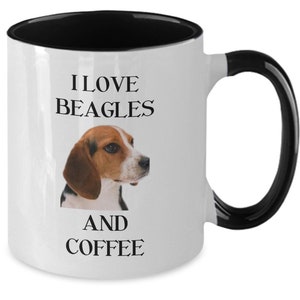 May include: White ceramic coffee mug with a black rim and handle. The mug has a beagle dog image and the text "I love beagles and coffee".