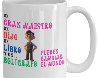 May include: White ceramic coffee mug with a cartoon illustration of a teacher holding a book and pen. The text on the mug reads "Un Gran Maestro Un Hijo Un Libro Y Un Boligrafo Pueden Cambiar El Mundo".