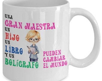 May include: White ceramic mug with a colorful illustration of a teacher holding a book. The text on the mug reads "Una Gran Maestra Un Hijo Un Libro Y Un Bolígrafo Pueden Cambiar El Mundo".