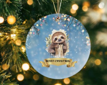 May include: A blue and white Christmas ornament featuring a cartoon sloth holding onto a branch. The ornament has a gold ribbon with the text "Merry Christmas" on it.