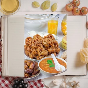 Peut inclure: Vue aérienne d'un livre de cuisine ouvert sur une page blanche, entouré de divers aliments. Comprend une soupe, des dattes, des pâtisseries, des œufs, du jus d'orange, des tomates, des pâtes et une cuillère en bois.