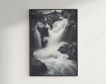 May include: A black and white photograph of a waterfall cascading over rocks. The water is flowing rapidly and creating a sense of movement. The rocks are dark and textured, providing a contrast to the white water.