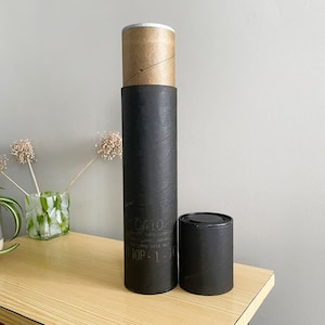 May include: Two black cardboard tubes, one taller than the other, with a brown paper label on the taller tube. The label has the text "GALO" and "ICP-1" on it.