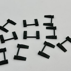 May include: Ten black plastic car ramps, each with a slightly different design. The ramps are designed to help lift a car for repairs or maintenance.