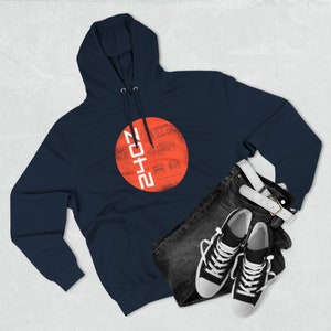 May include: A navy blue hoodie with a red circle on the front. The circle has a white design of a car and the text "2012" in white.