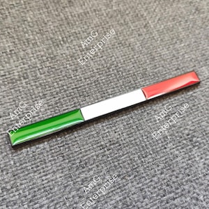 May include: A rectangular Italian flag badge with green, white, and red stripes. The badge is a long, thin rectangle with a shiny finish. The text "AmG Enterprise" is printed on the background.