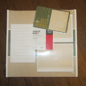 May include: A scrapbook kit with a beige background and green and white borders. The kit includes a sheet of lined paper, a sheet of blank paper, and a sheet of decorative paper with the text "You Better Beleaf It" and "the best memories".