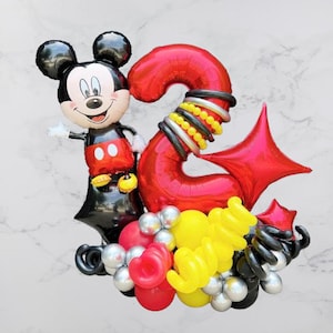 May include: A red number two balloon with black and yellow accents, a black Mickey Mouse balloon, and a variety of other balloons in red, yellow, black, and silver.