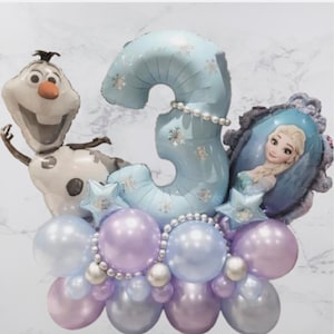 Puede incluir: Arreglo festivo de globos para un cumpleaños. Incluye un gran globo con el número 3, un globo de Olaf y un globo de Elsa. Los globos son azules, morados y plateados, con detalles de perlas. Perfecto para un tercer cumpleaños.